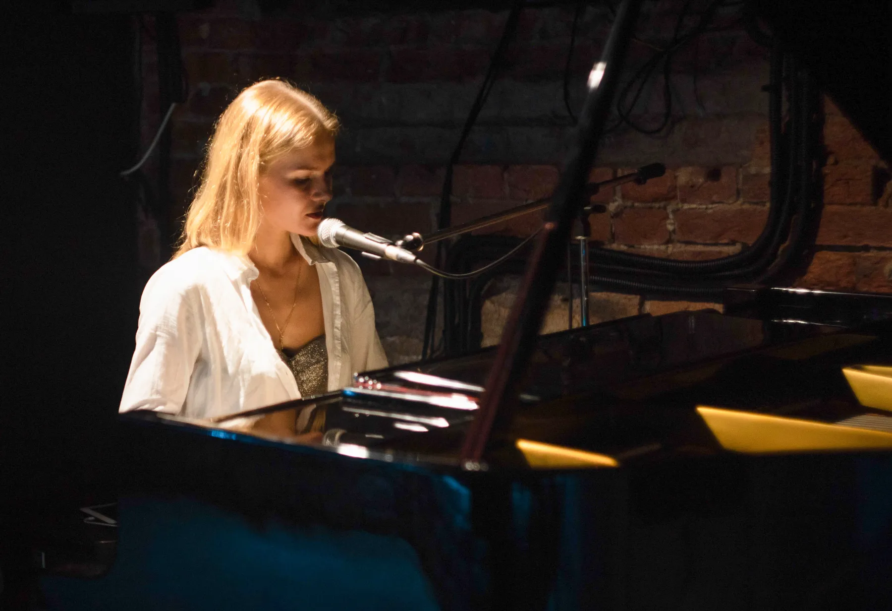 Marina Malina performing vocals at a grand piano