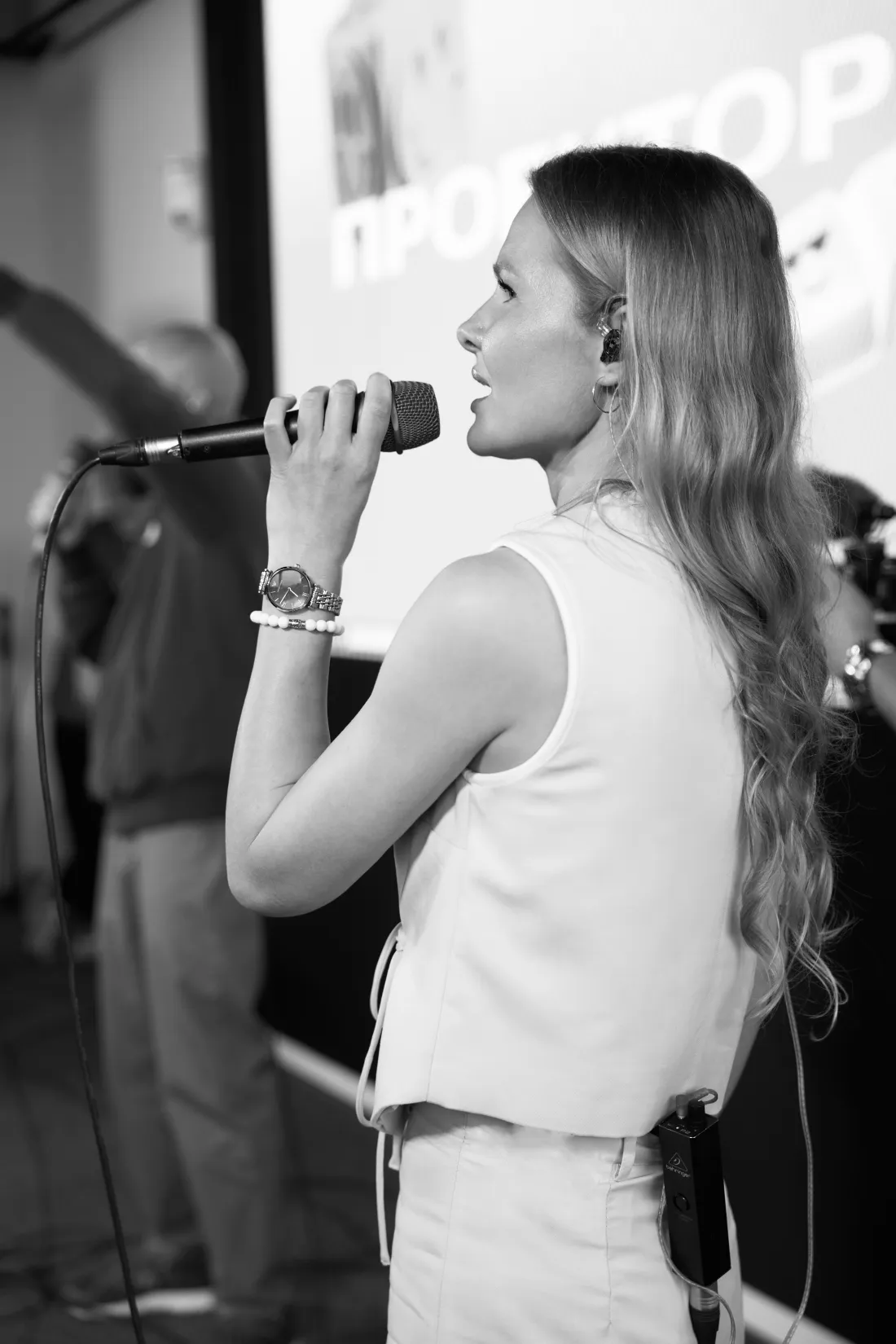 Marina Malina singing into a handheld microphone during a live performance